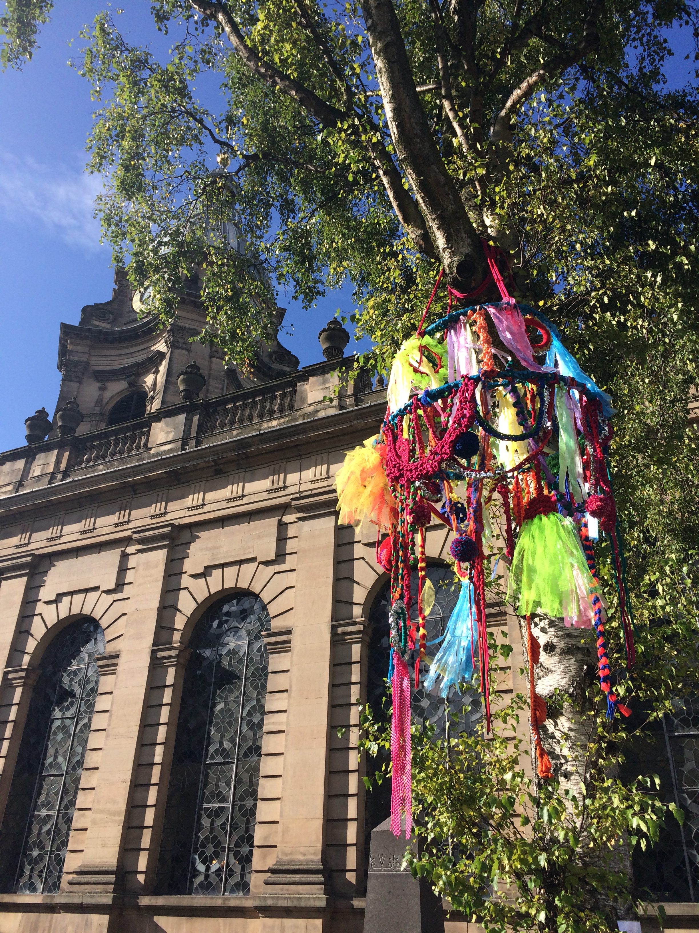 the large-scale brightly coloured chandelier was hung up in the tree in front of the Cathedral