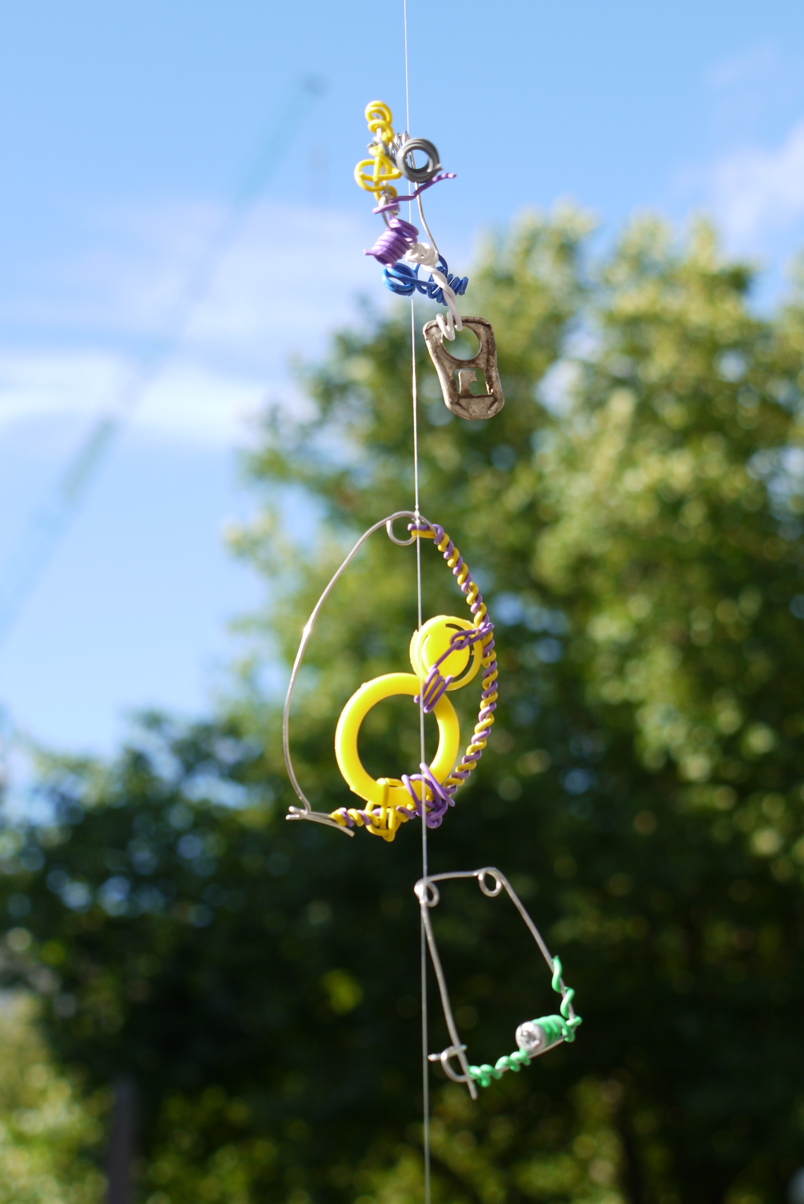 made from found objects such as rusted metals and twigs, with silver and colourful covered metal wire