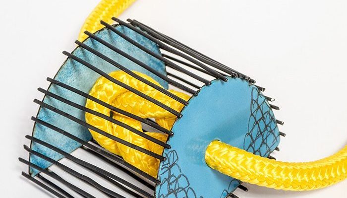 Jewellery incorporating metal, yellow rope and blue enamel.