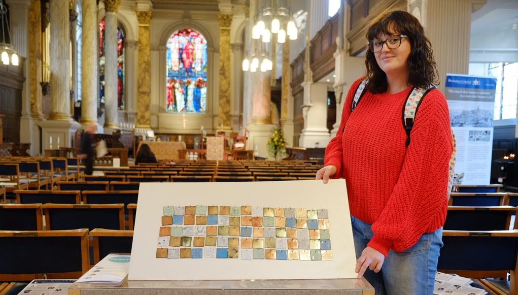 The artist shows proudly the tiled collection of drawings
