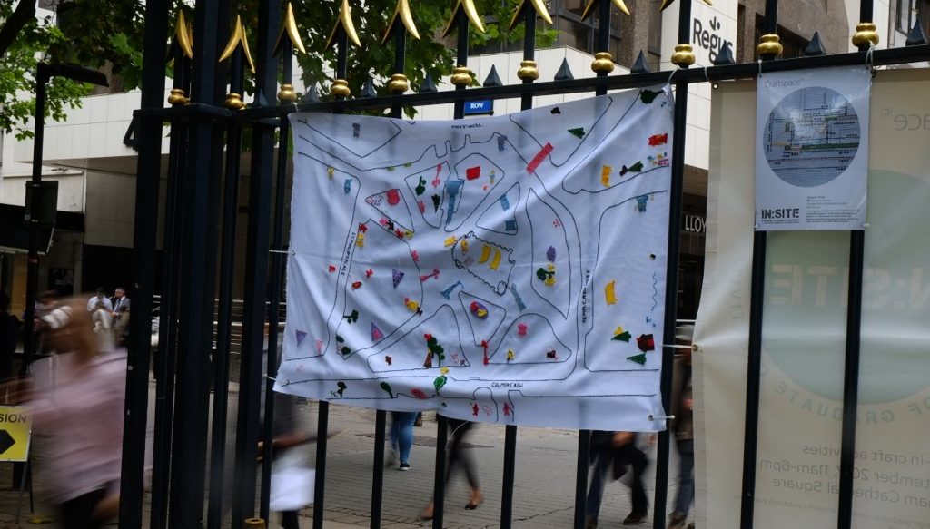 embroidered map hung on railings
