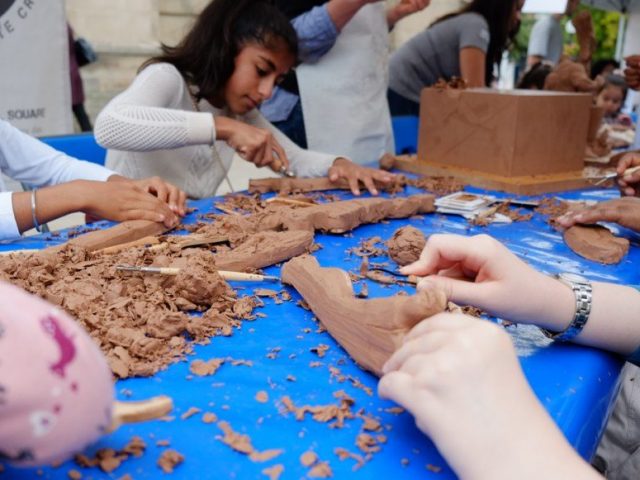 People of various ages sculpt clay using various tools.