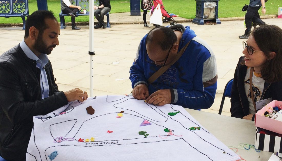 People are sewing something on the map of Cathedral Square.
