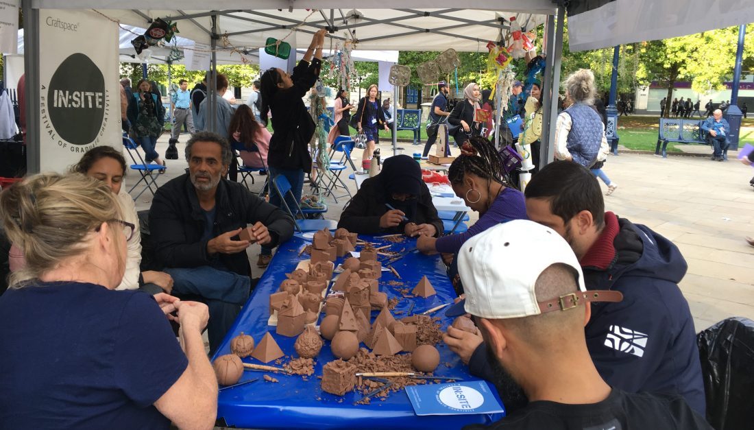 groups of people sitting around table carving into clay