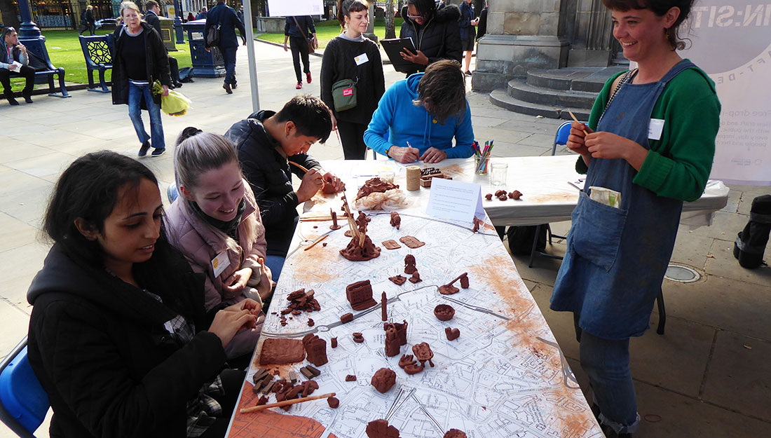 table with people making small clay sculptures